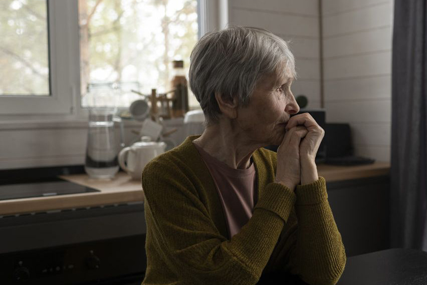 Photo of a worried woman in a mustard cardigan
