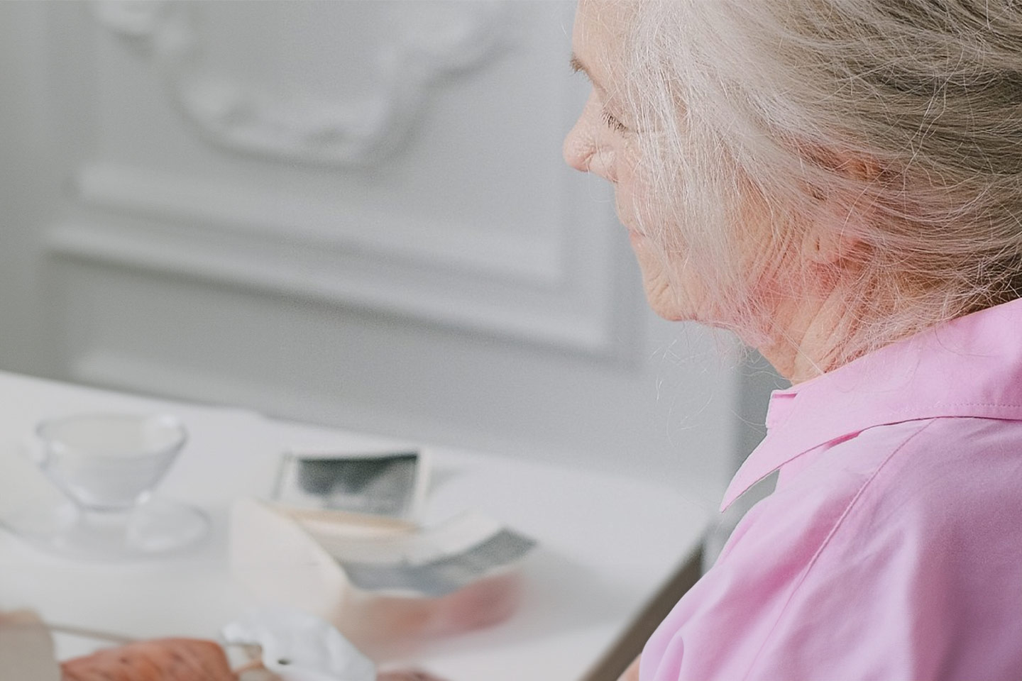 Photo of white-haired lady in a pink shirt