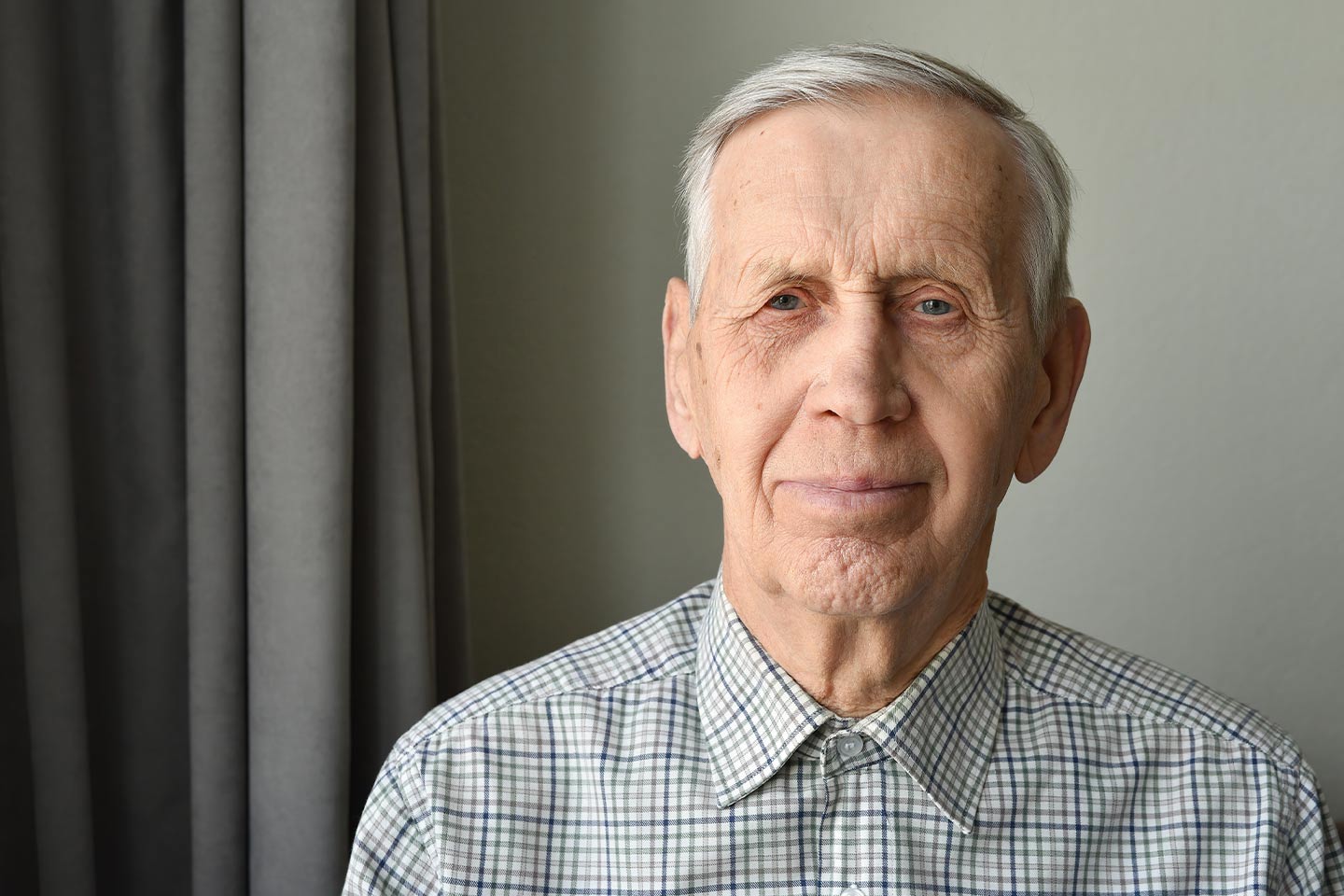 Photo of man in a grey check button-up shirt