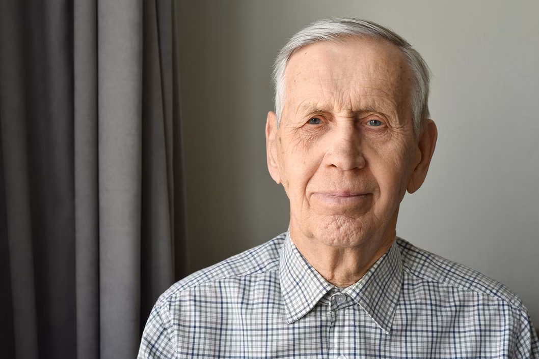 Photo of man in a grey check button-up shirt