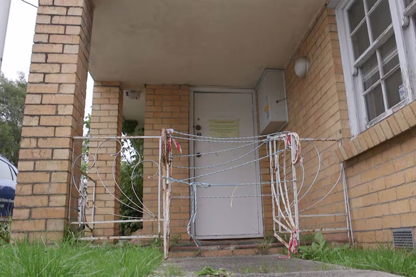 Photo of gate in front of a condemned building