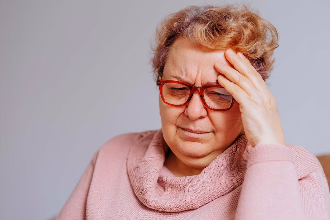 Photo of woman wearing red glasses and pink jumper