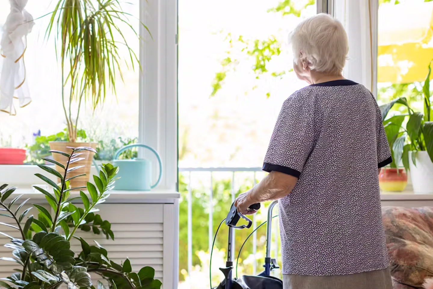 Photo of a woman with a walker surrounded by plants