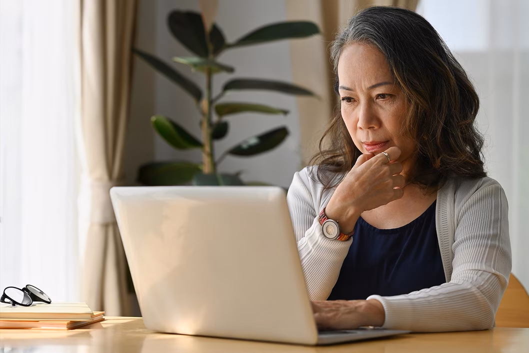 Photo of a woman sitting in front of a laptop