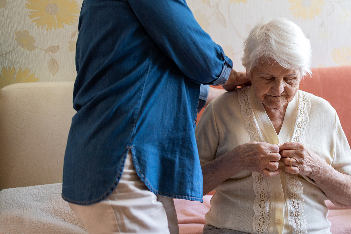 Photo of woman getting dressed with help from another person