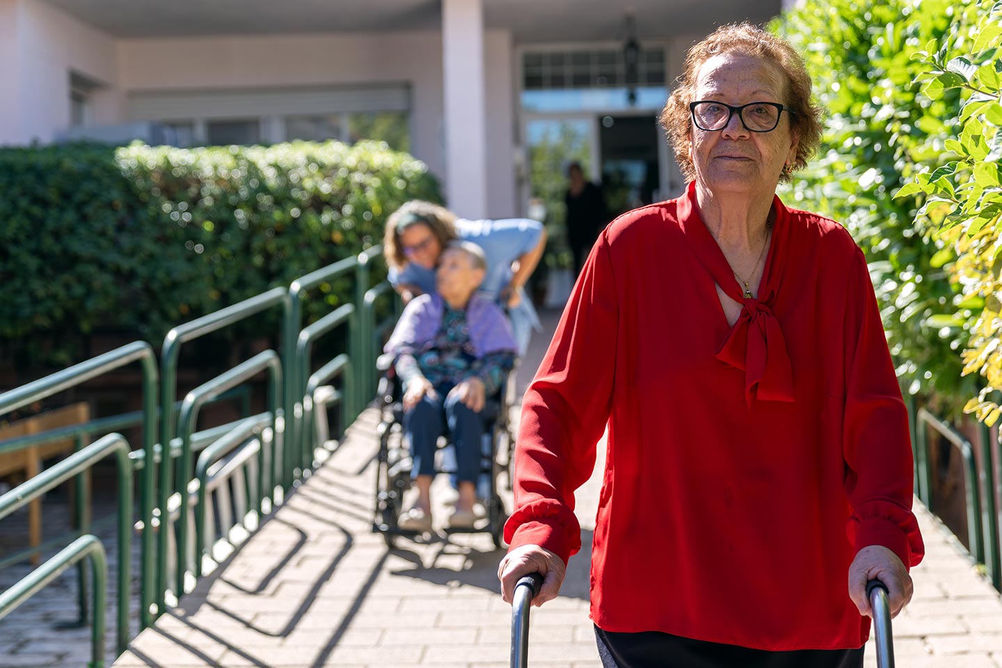 Photo of a woman in a red blouse walking outside