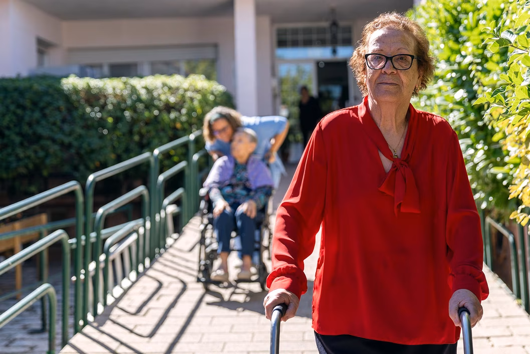 Photo of a woman in a red blouse walking outside