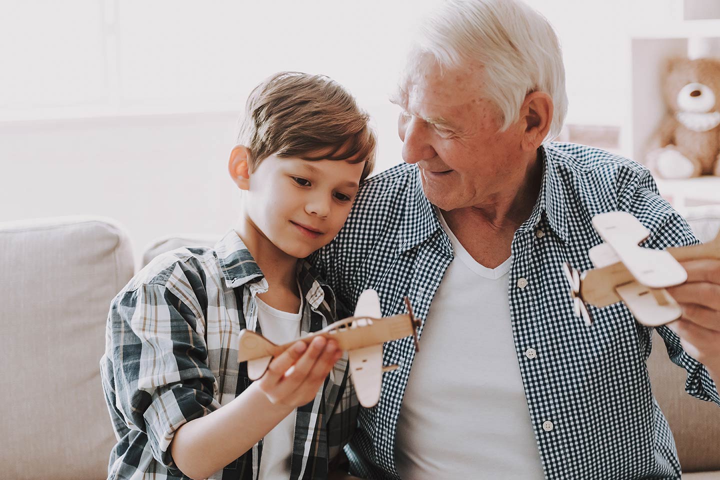 Photo of young person and senior person with model airplanes