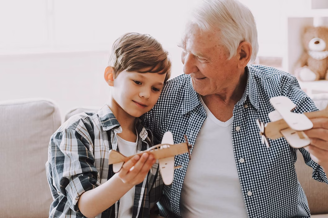 Photo of young person and senior person with model airplanes