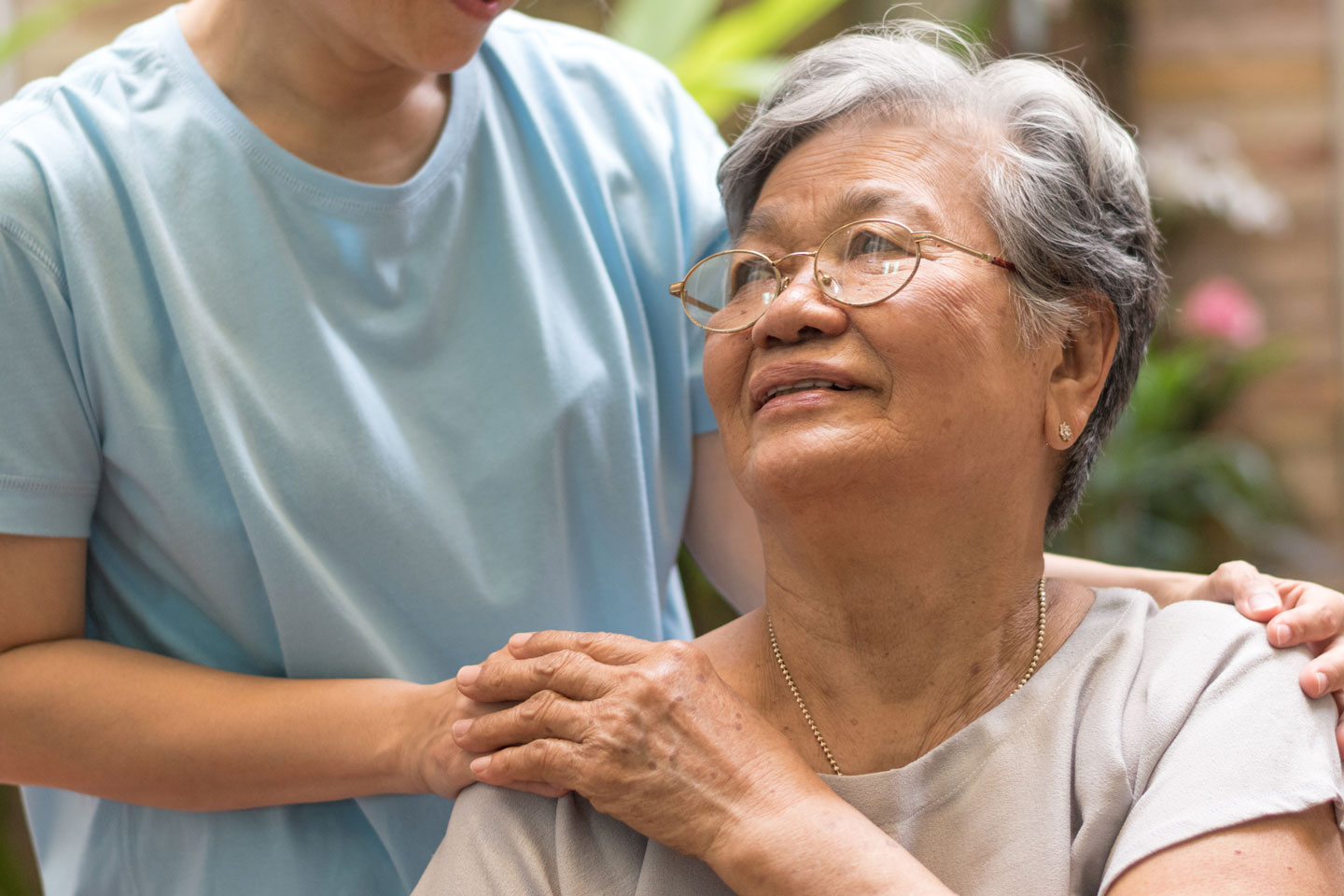 Senior woman holding carers hand