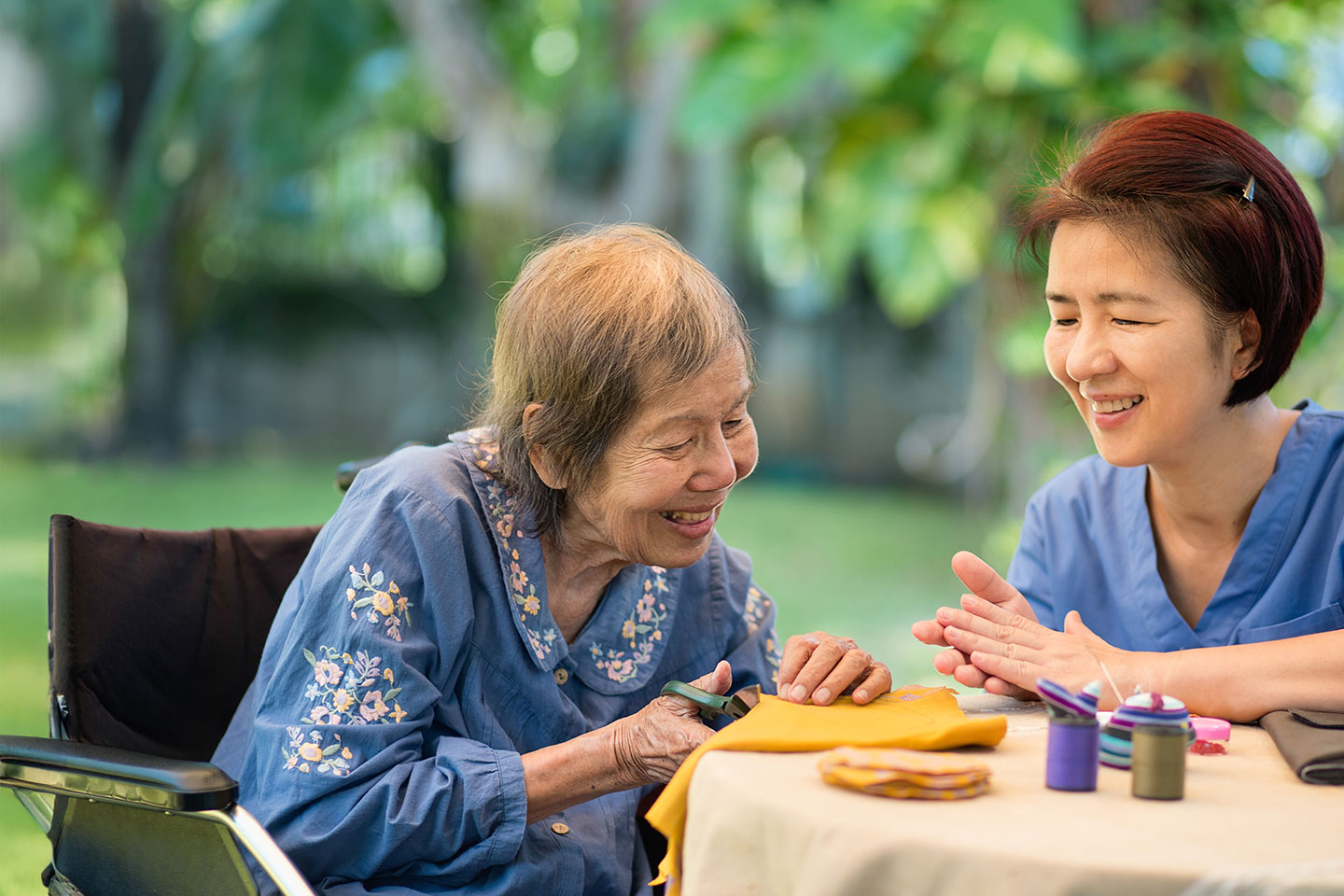 Photo of two women crafting at a table outdoors