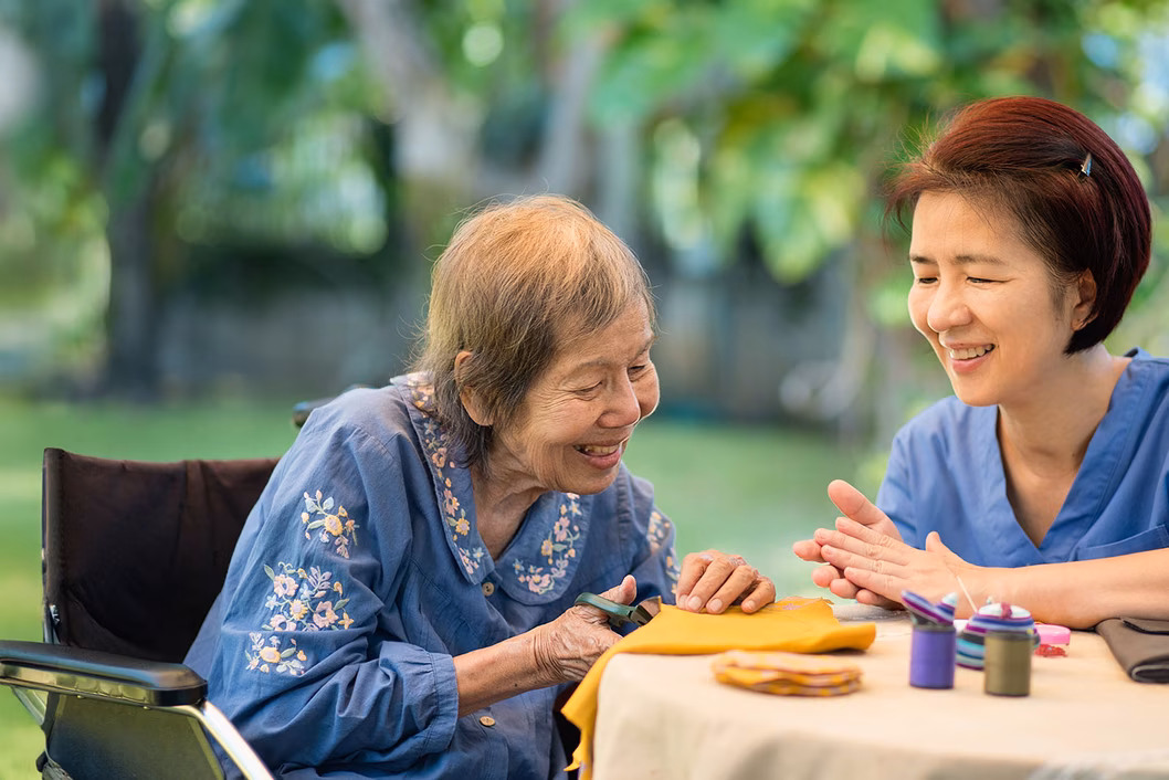 Photo of two women crafting at a table outdoors