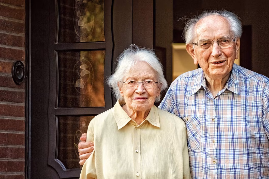 Photo of an older couple smiling at the camera