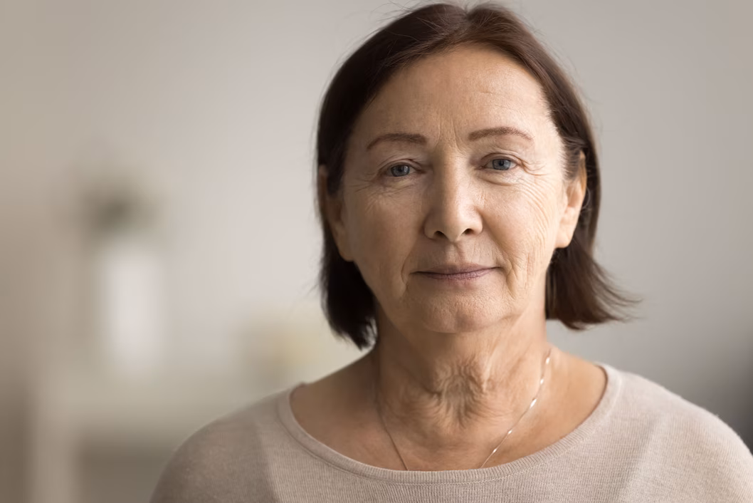 Photo of a woman with a brown bob and wearing a cream knit