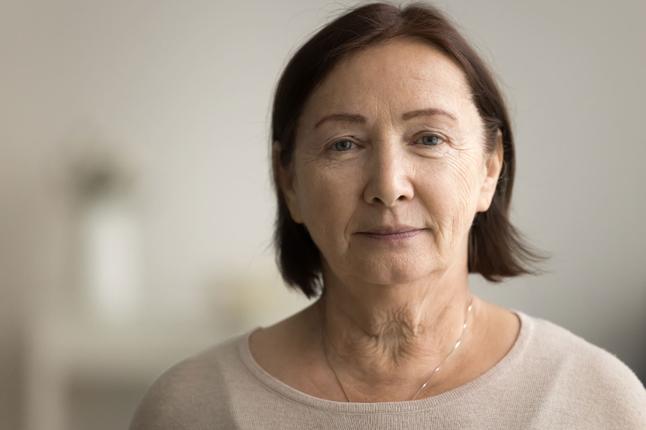Photo of a woman with a brown bob and wearing a cream knit