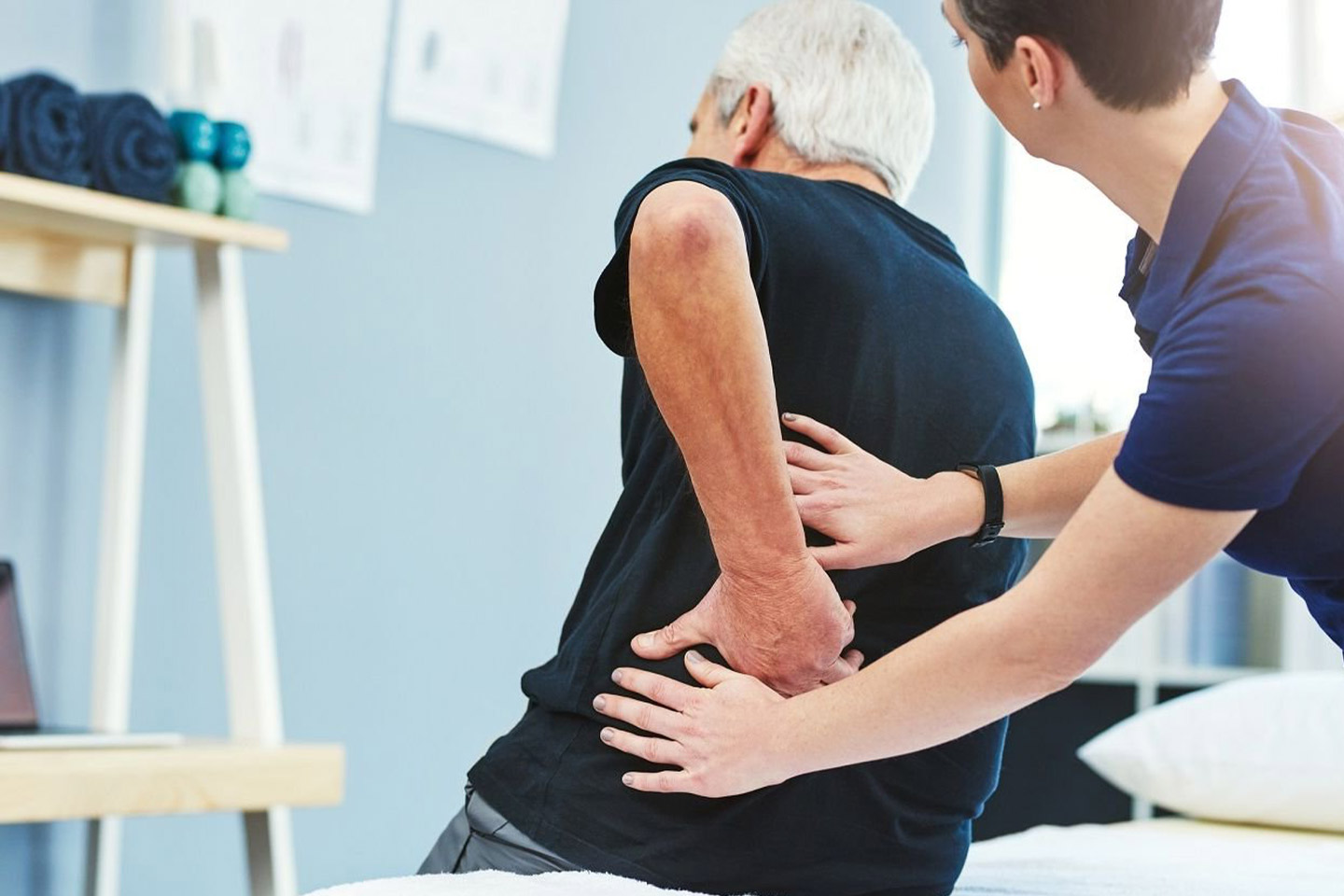 Photo of a physio helping a man with his back