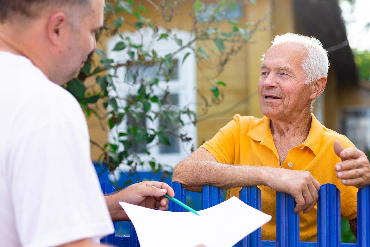 Photo of contractor and homeowner chatting over garden gate