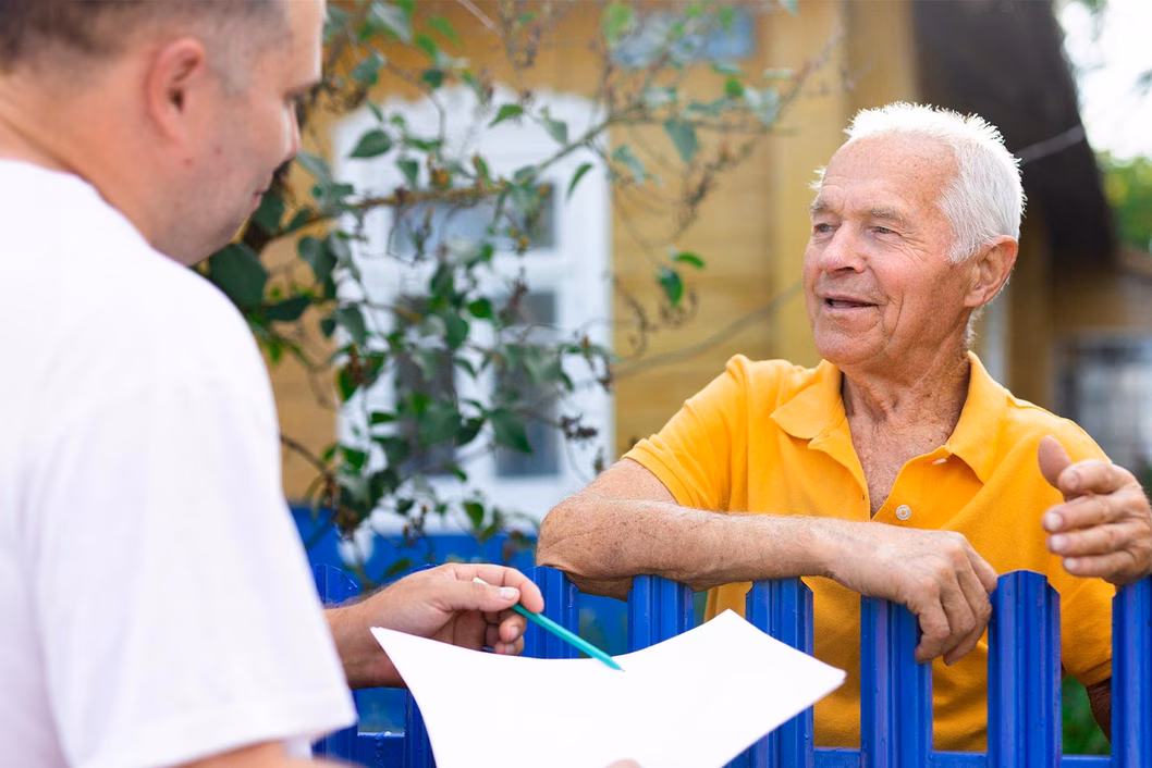 Photo of contractor and homeowner chatting over garden gate