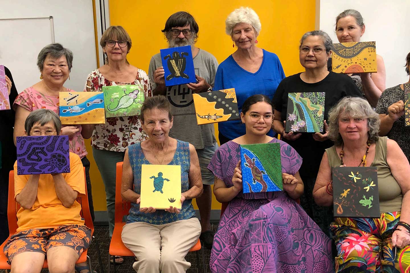 Photo of a group holding artworks