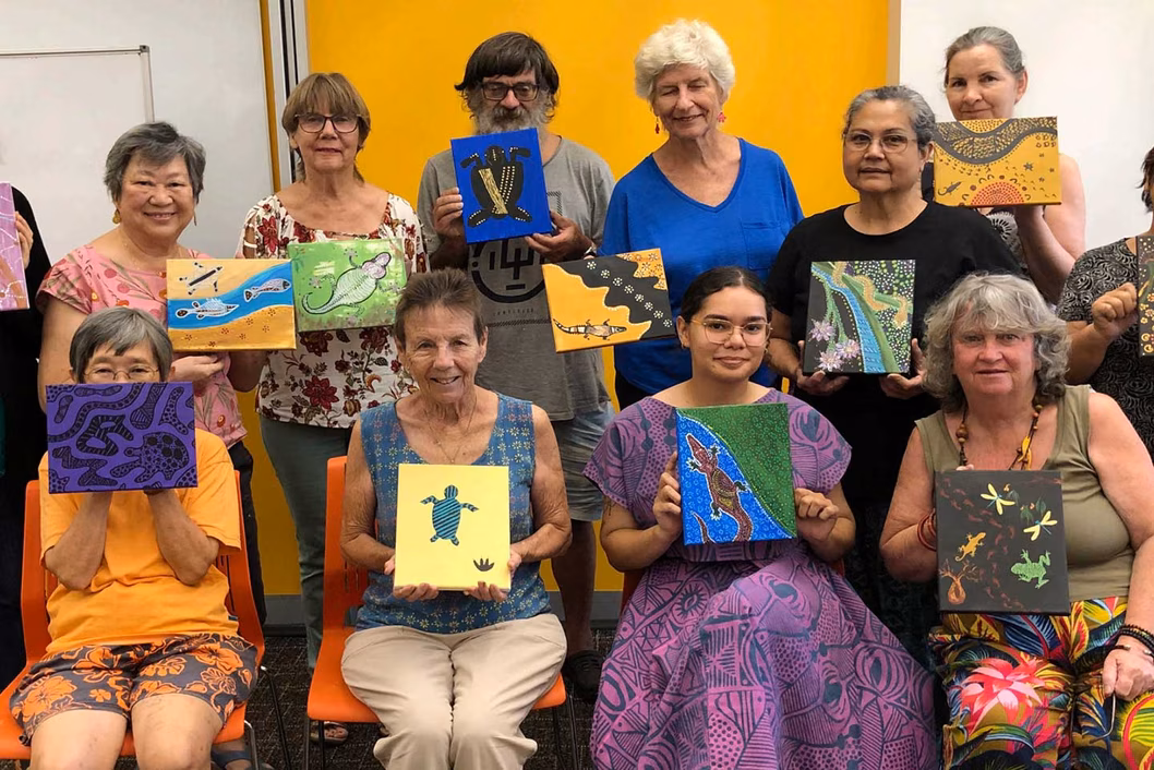 Photo of a group holding artworks