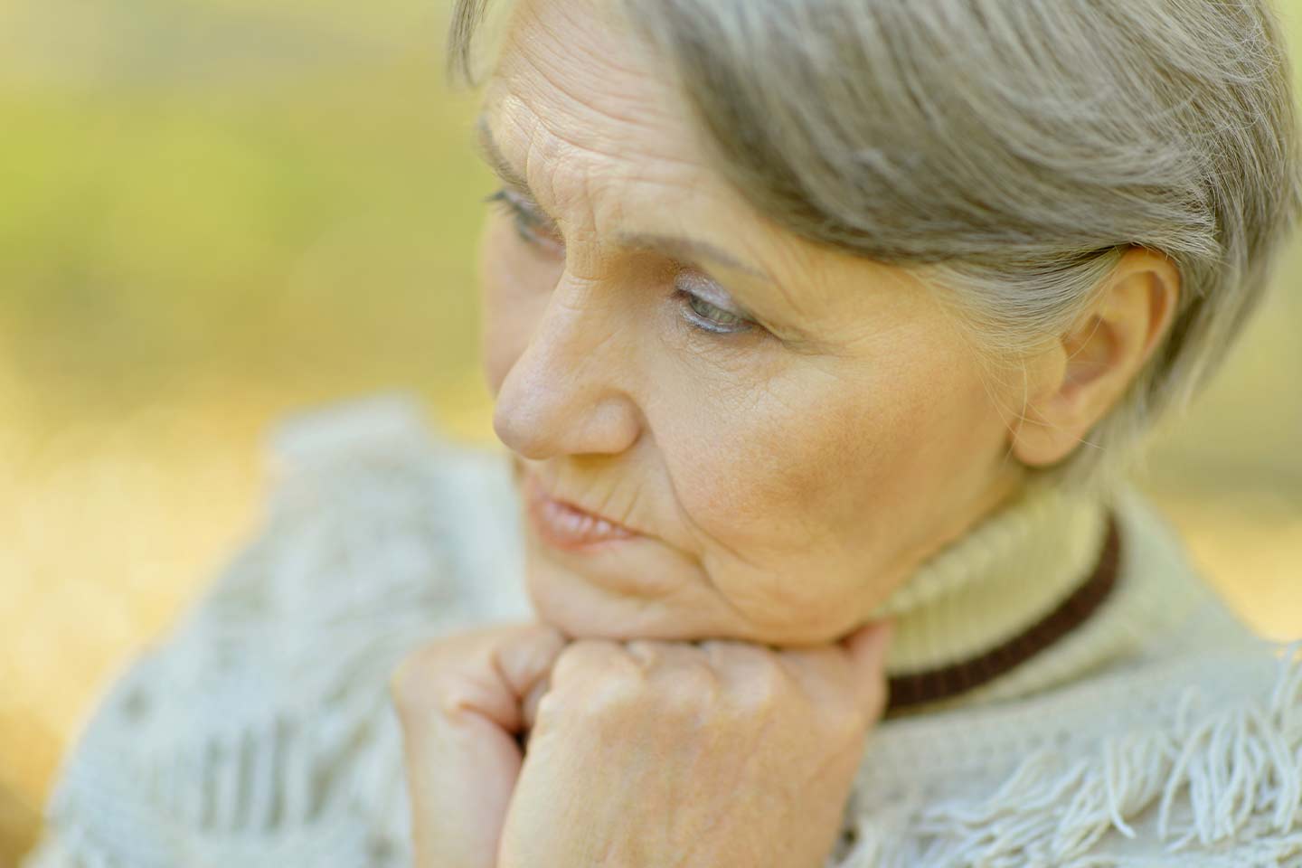 Photo of a woman wearing a fringed grey jumper