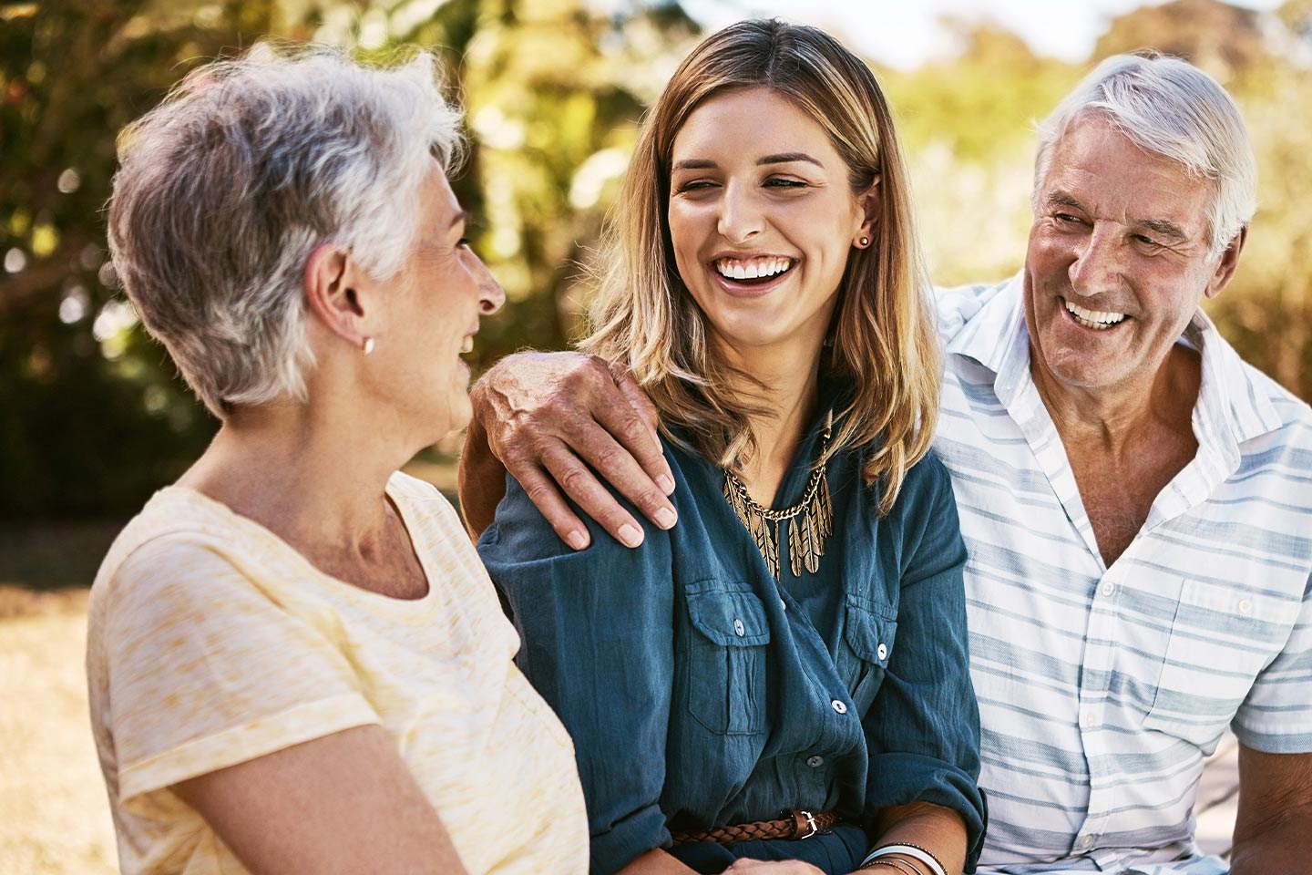 Photo of parents laughing with their adult daughter
