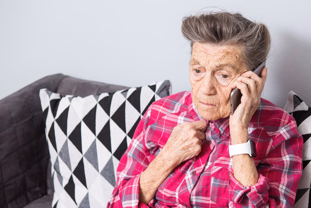 Photo of person on a mobile phone wearing a fuchsia plaid shirt