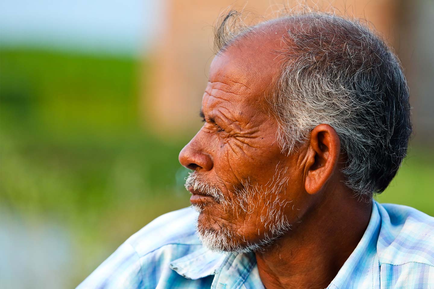 Photo of a man wearing a pale blue plaid shirt
