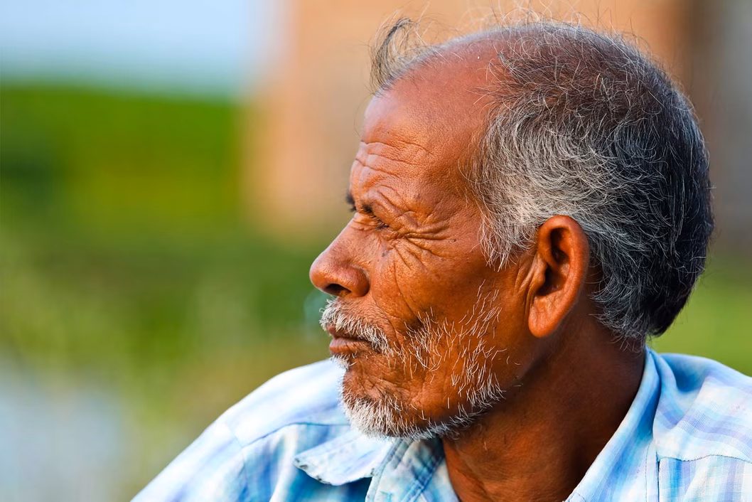 Photo of a man wearing a pale blue plaid shirt