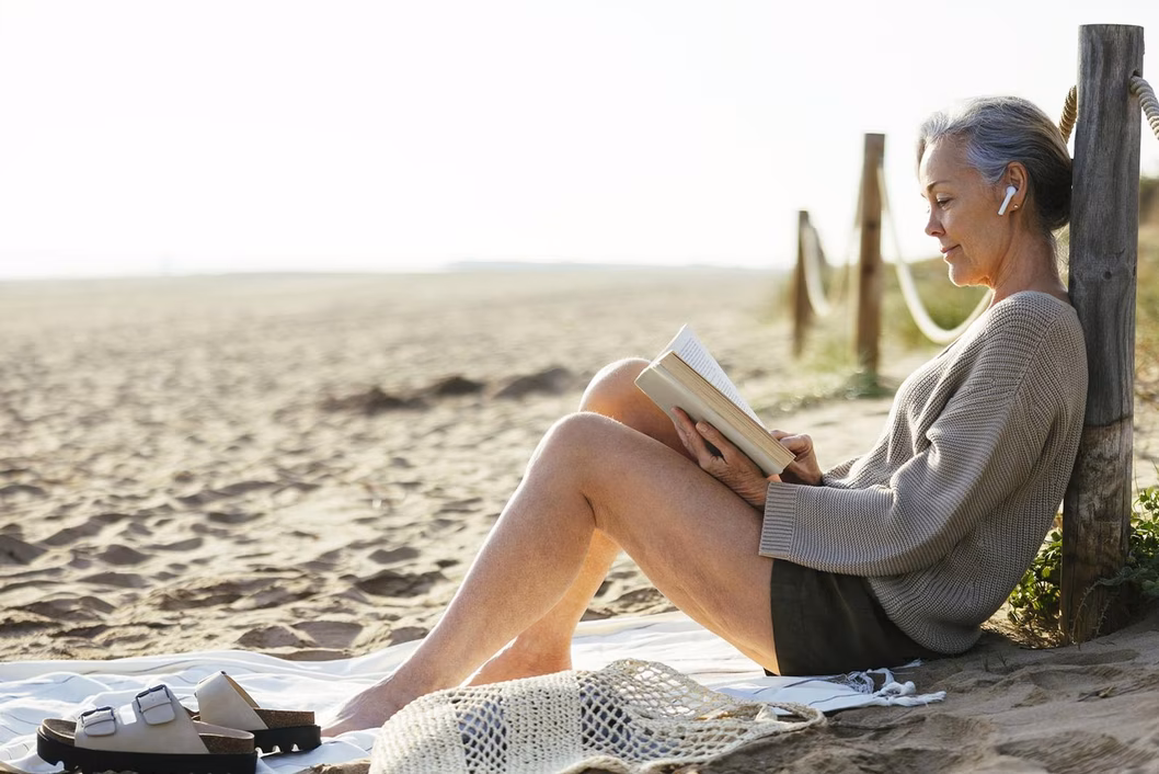 Photo of woman reading on a beach