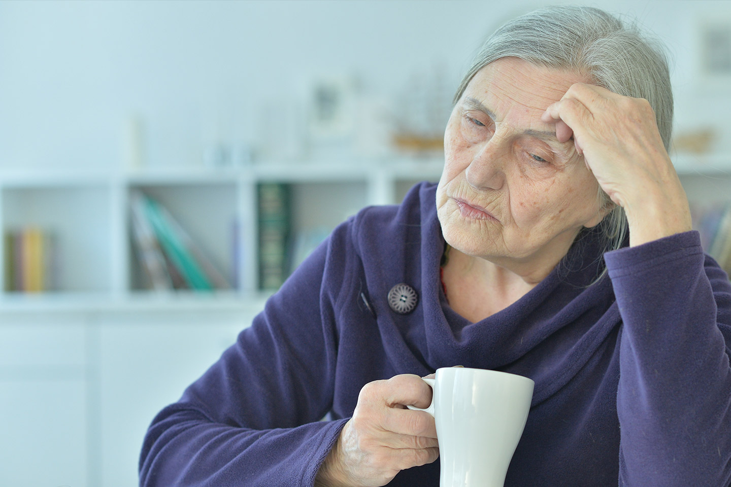 Photo of a woman in a purple robe holding a white mug