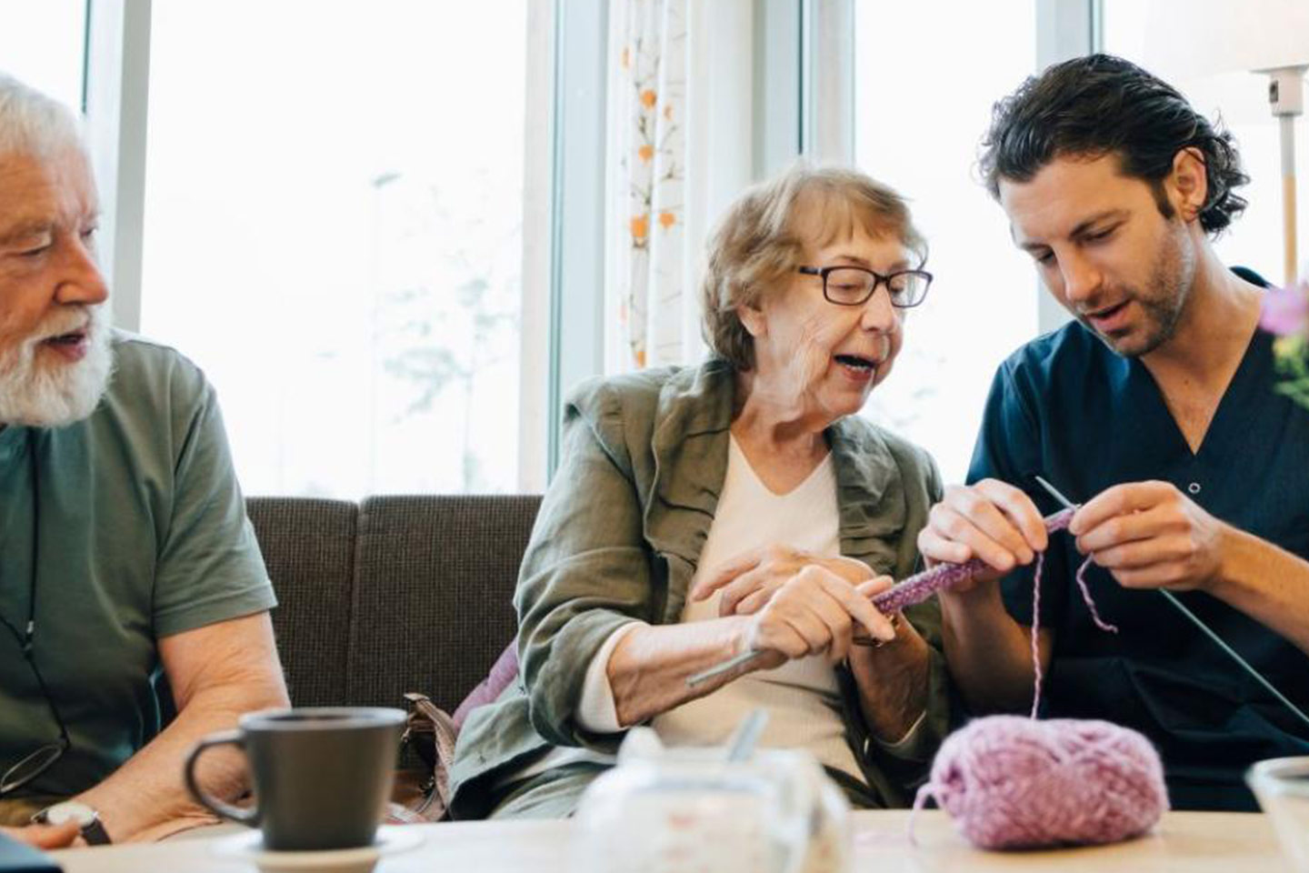 Photo of a woman showing a man how to knit