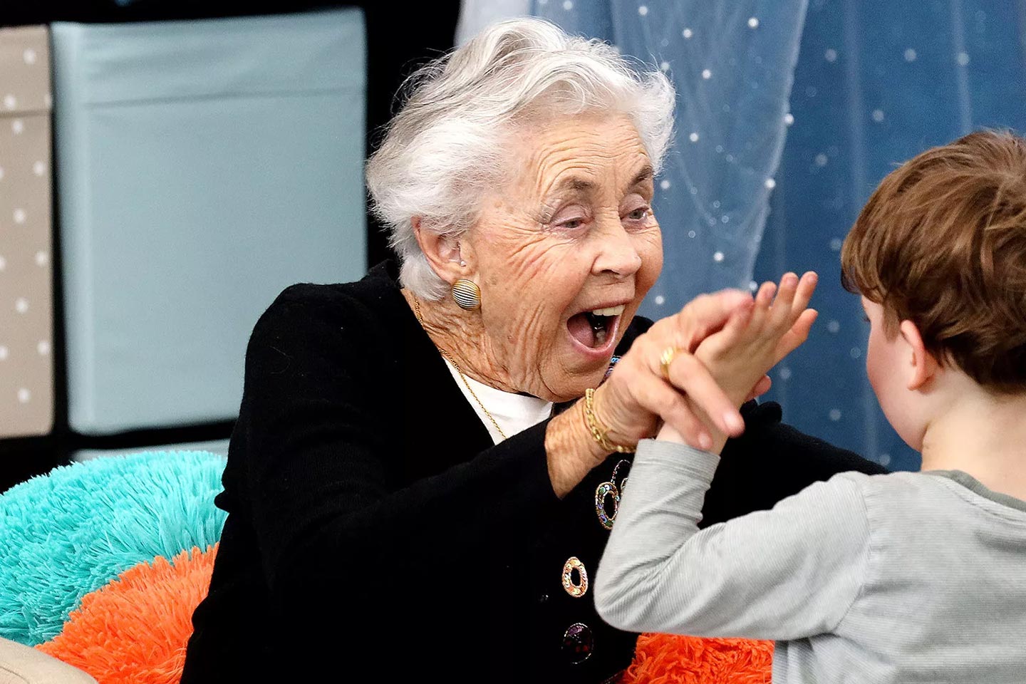 Photo of a senior woman playing with a toddler