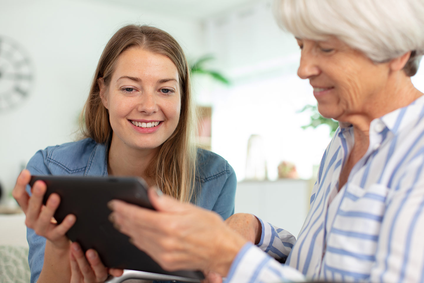 Photo of two people in blue shirts looking at a tablet