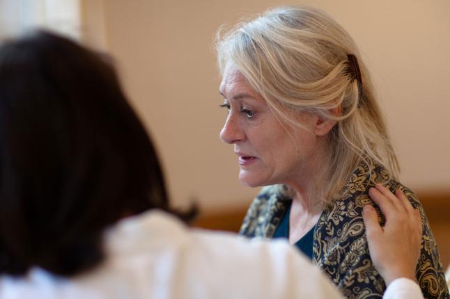 Image of an older woman being consoled by a counsellor