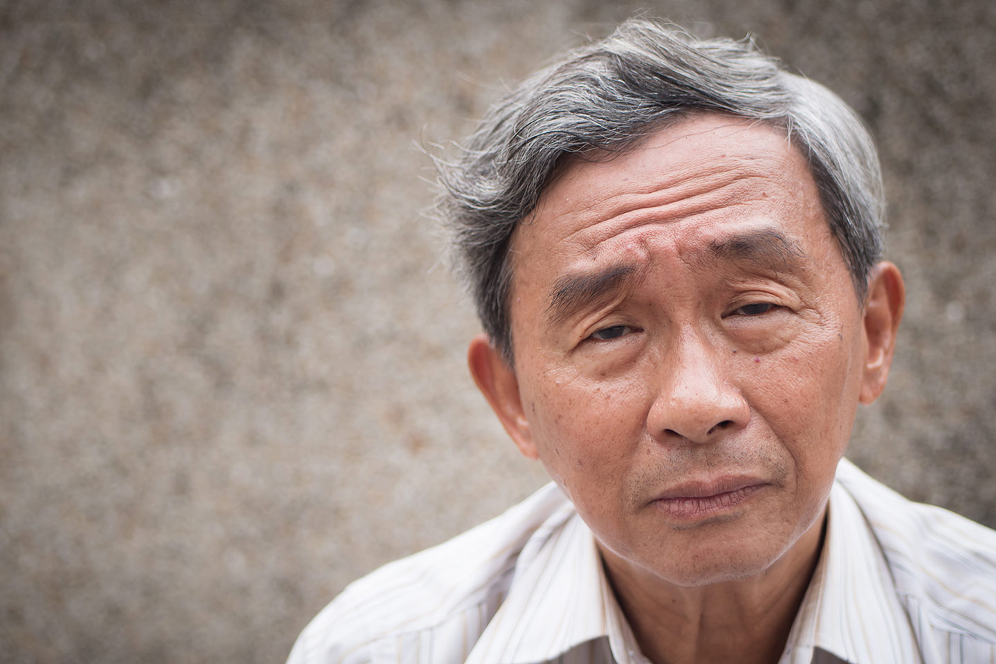 Photo of a man with a white shirt and a furrowed brow