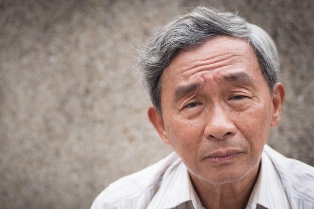 Photo of a man with a white shirt and a furrowed brow