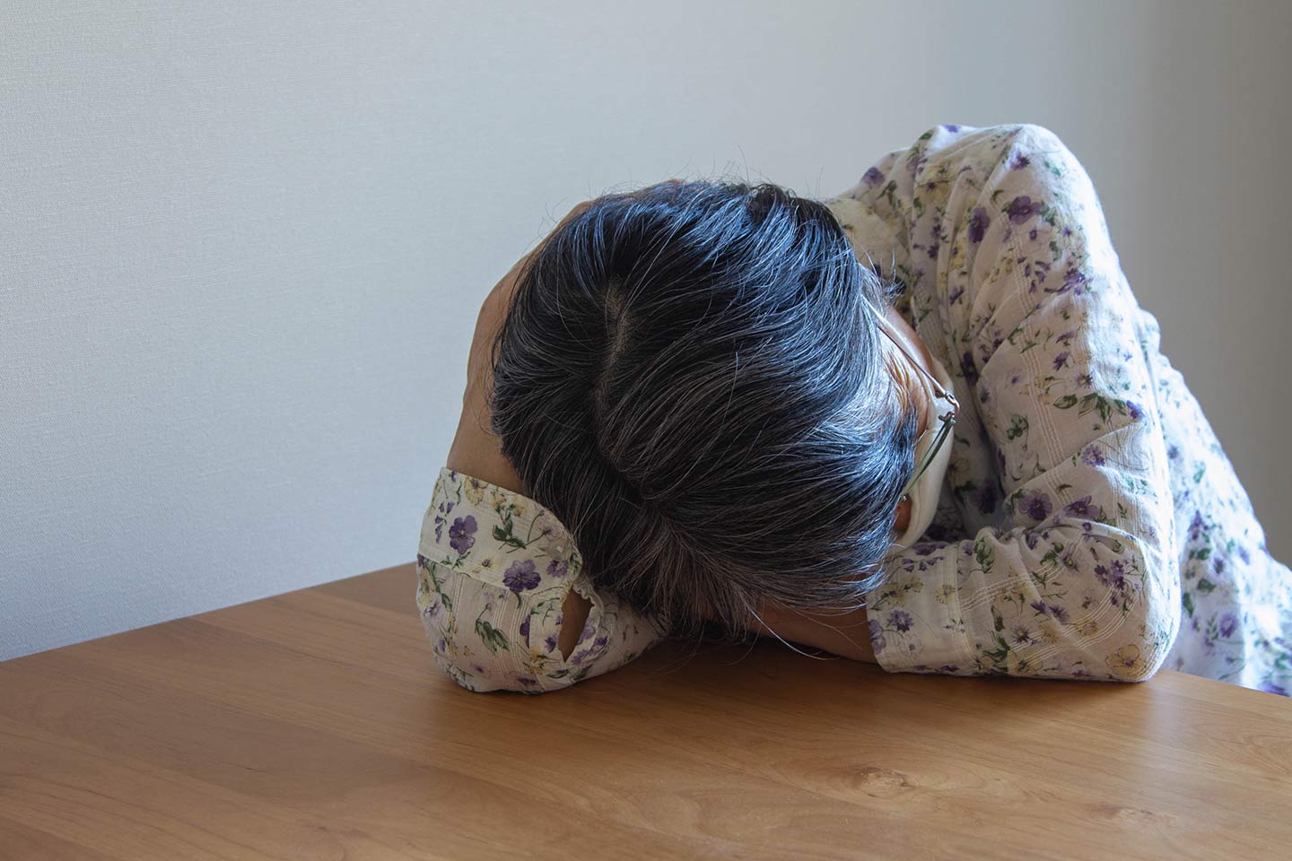 Photo of a person with their head on a table