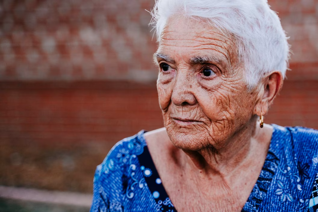 Photo of a woman with short white hair in a blue dress