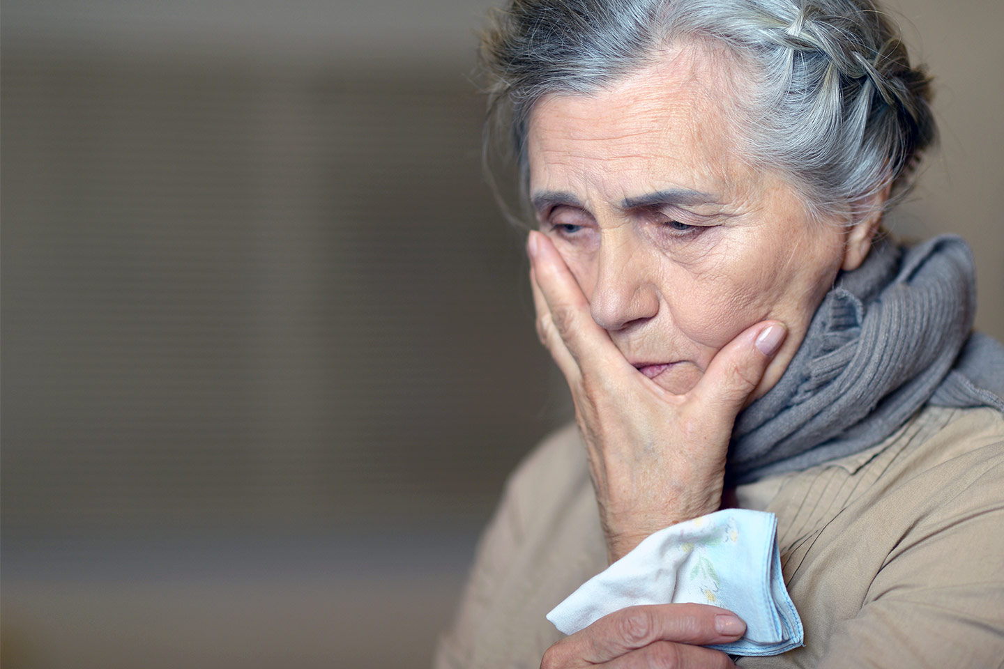 Photo of a woman with a hankie and her hand over her mouth