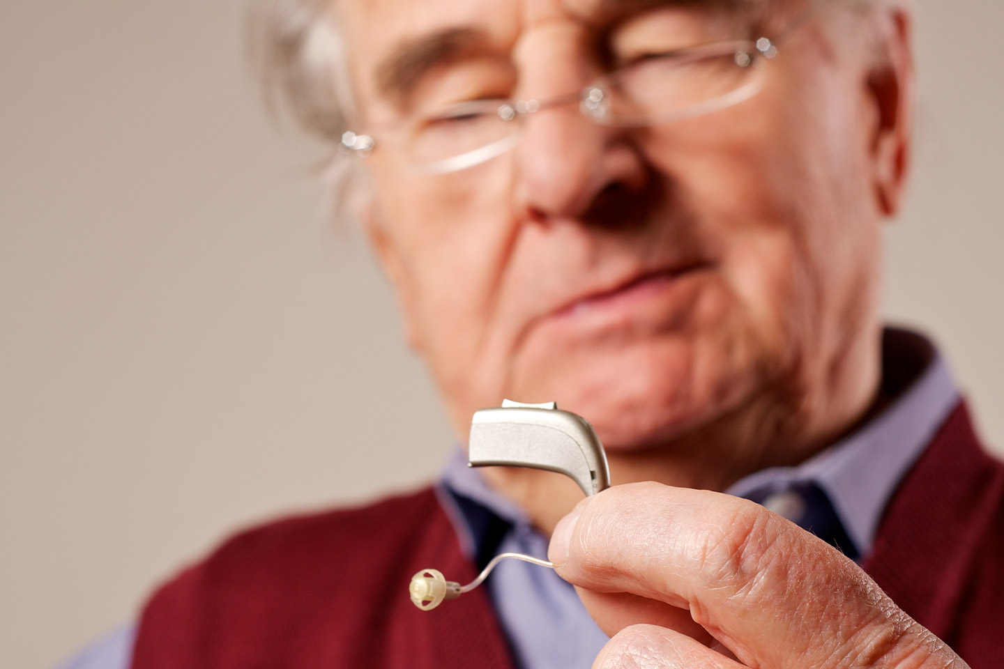 Photo of a man holding a hearing aid