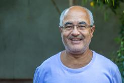 Image of an older man wearing glasses and a blue t shirt