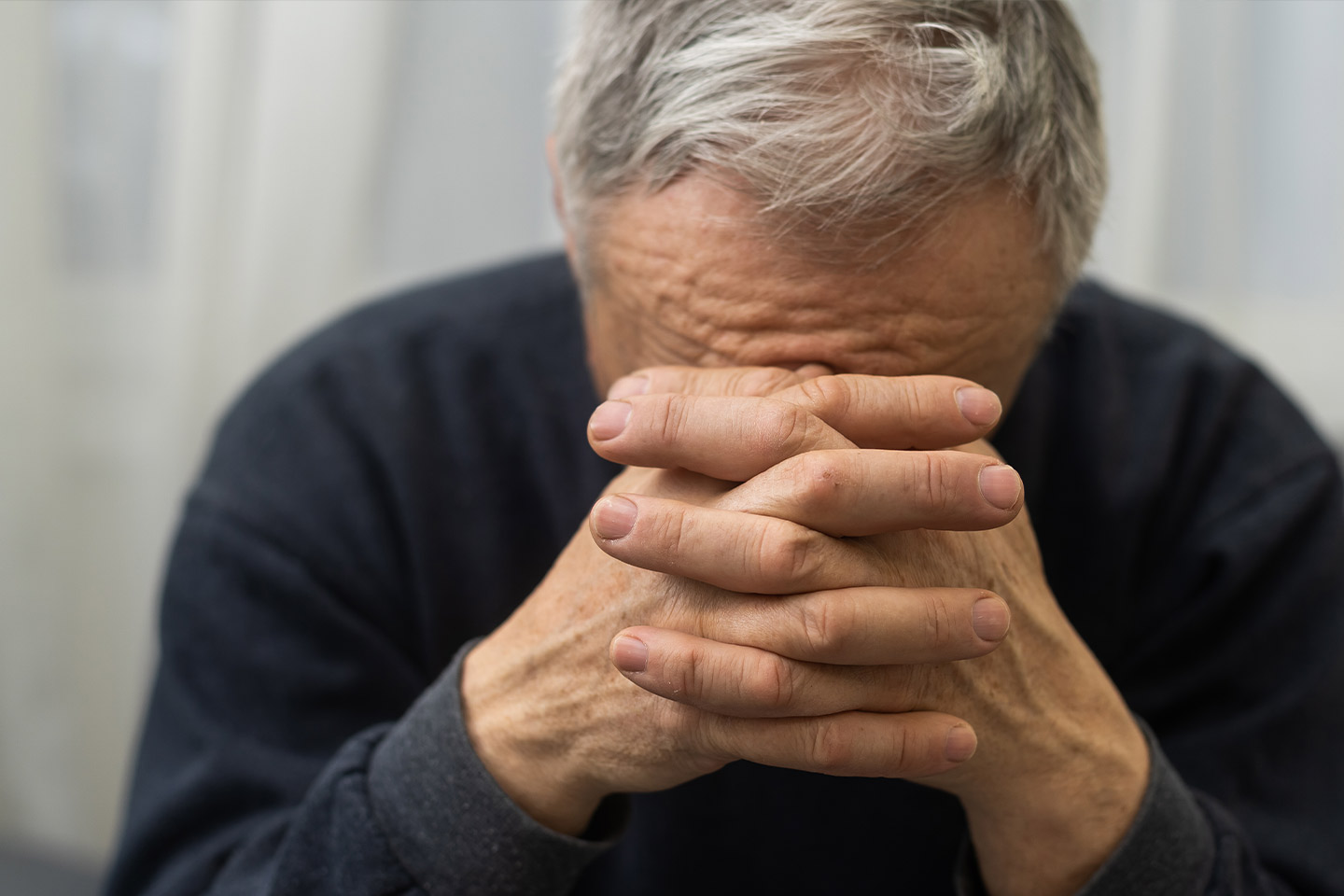 Photo of a man with his head on his hands