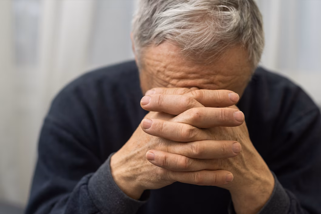 Photo of a man with his head on his hands