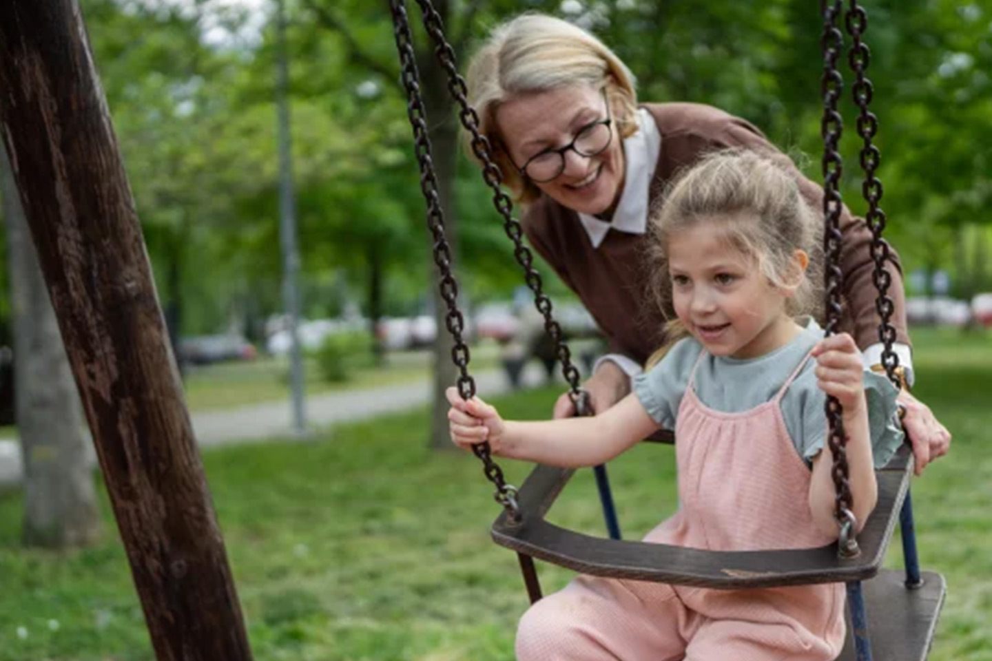 Photo of a woman pushing a child on a swing