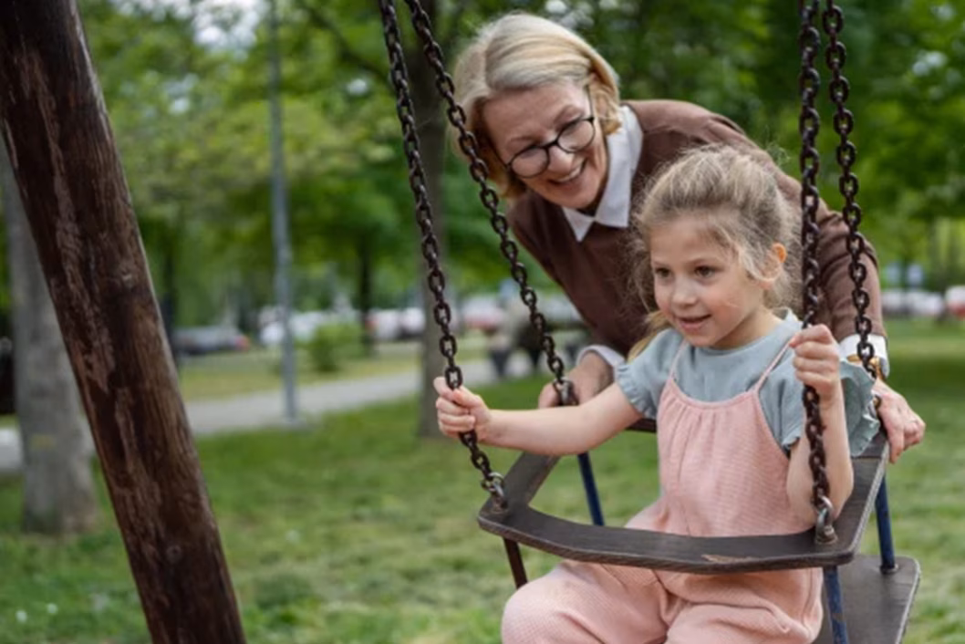 Photo of a woman pushing a child on a swing