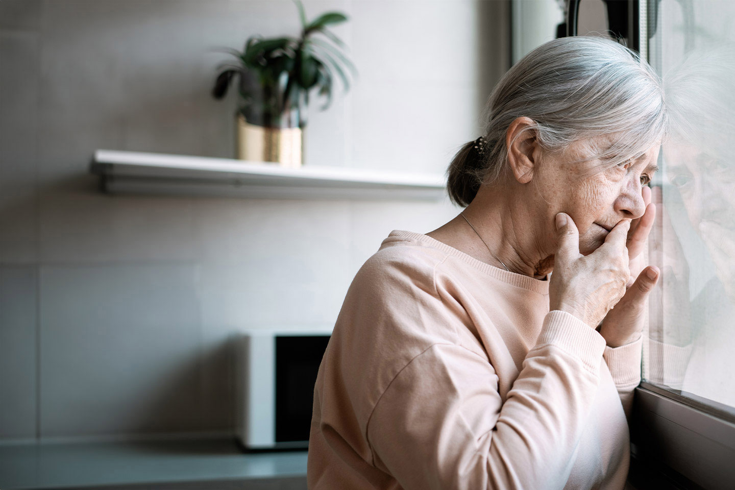 Image of an older woman looking out a window