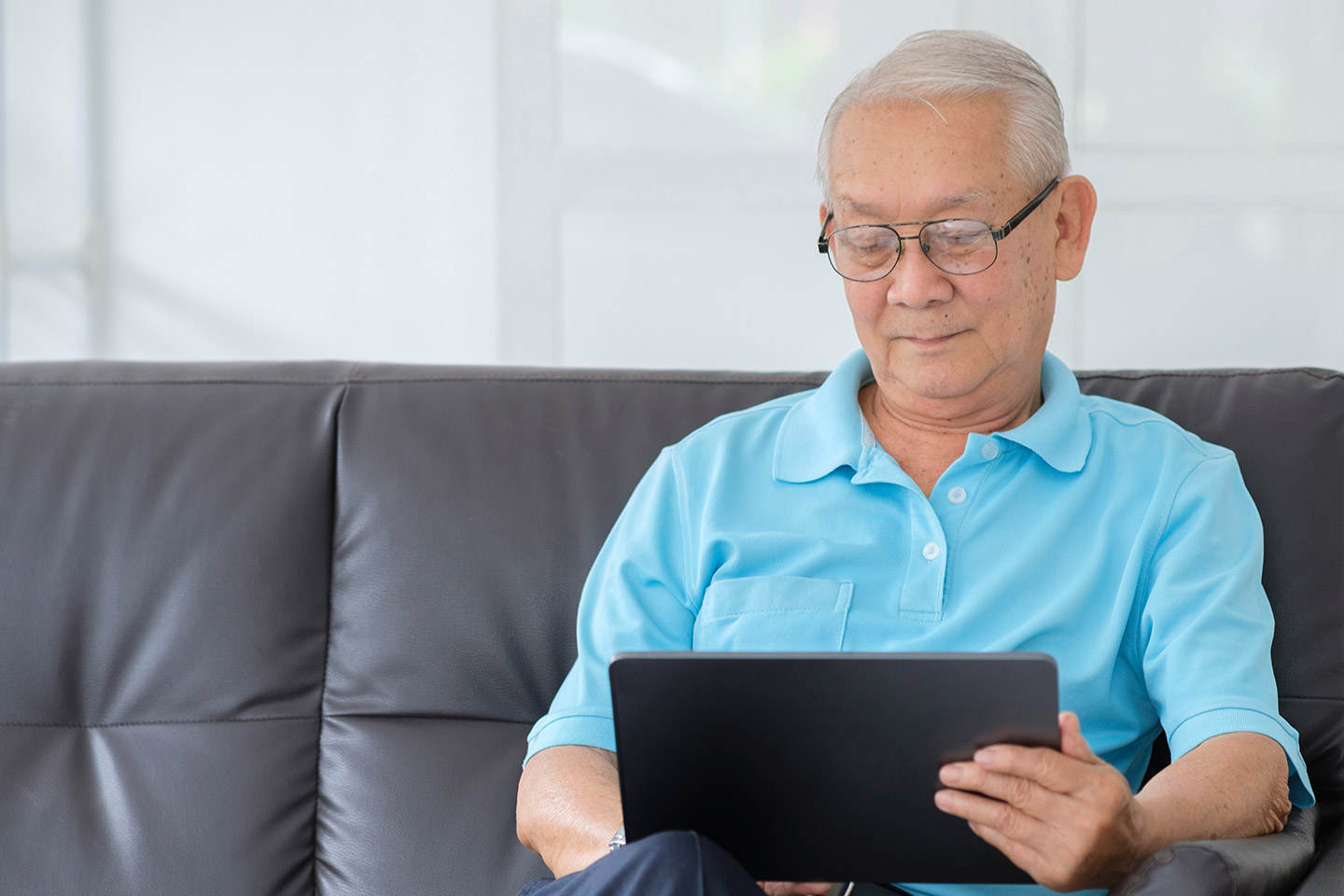 Photo of a man in a sky blue shirt with a laptop