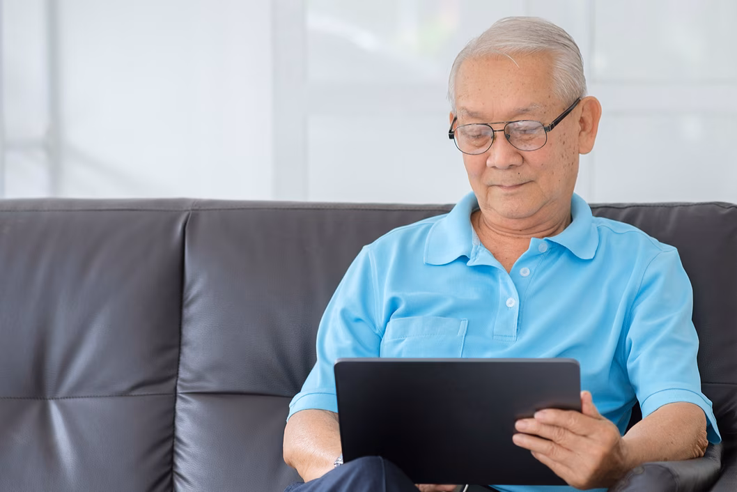 Photo of a man in a sky blue shirt with a laptop