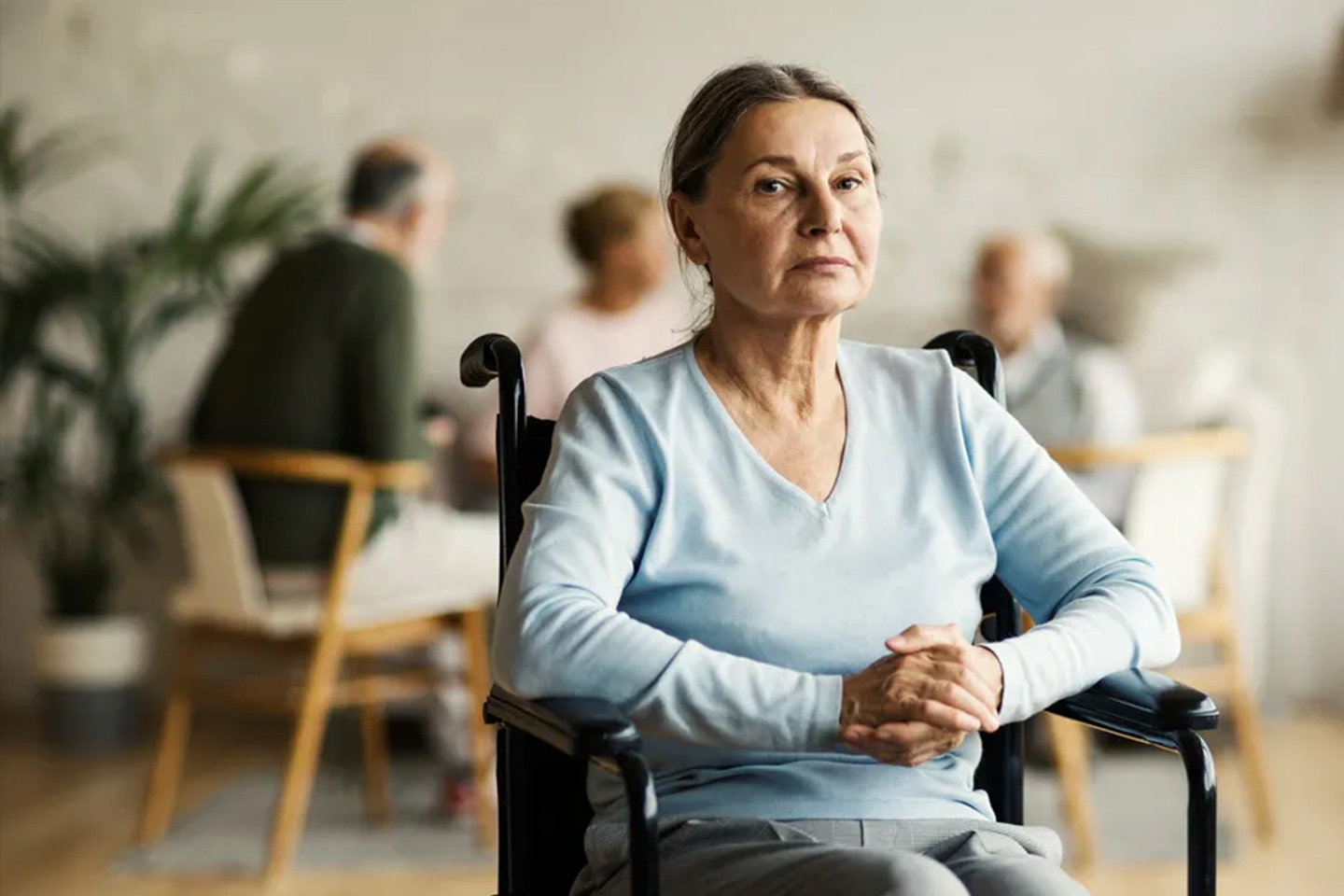 Photo of a woman wearing a baby blue top in a wheelchair